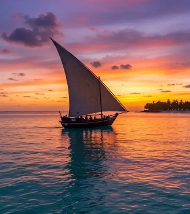 Dhow a vela silhouette contro un tramonto arancione sull'oceano