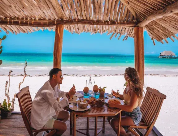 Terrazza sulla spiaggia del Mvuvi Boutique Resort con tavolo apparecchiato e vista sull'oceano
