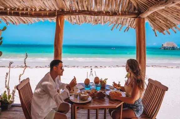 Terrazza sulla spiaggia del Mvuvi Boutique Resort con tavolo apparecchiato e vista sull'oceano