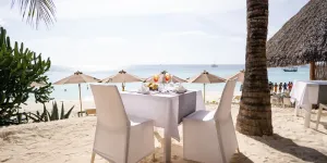 Tavolo apparecchiato in spiaggia al tramonto, My Blue Hotel
